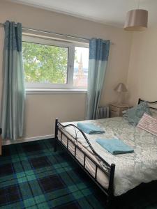 a bedroom with a bed and a large window at Budget Rooms in Inverness