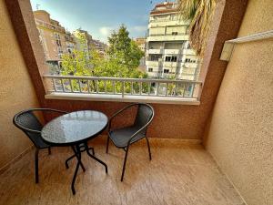 un balcone con 2 sedie, un tavolo e una finestra di COSTA BLANCA a Torrevieja