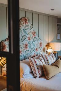 a bed with a floral headboard and pillows on it at Finch's Arms in Oakham