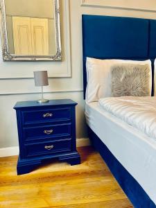 een blauw bed met een blauw nachtkastje met een lamp erop bij Beb c’est lavis in Lavis