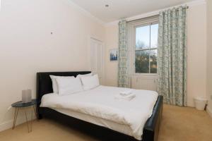 um quarto com uma cama grande e uma janela em Beautiful Home In Stockbridge Edinburgh em Edimburgo