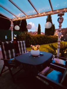 una mesa y sillas en un patio con luces en Apartment Glesch, en Bergheim