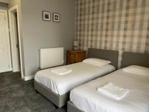 a bedroom with two beds and a table with a dresser at Inn On The Wye in Ross on Wye