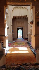 un couloir vide dans un bâtiment ancien avec une porte dans l'établissement Kasbah Maktob Tamnougalt, à Agdz