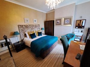 a bedroom with a bed and a table and a desk at The Ambassador Townhouse in Southport +110 photos