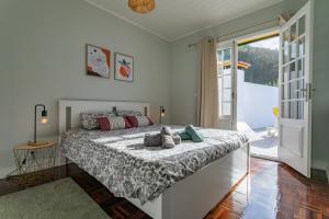 um quarto com uma cama e uma porta de vidro deslizante em Casa da Praia dos Moinhos na Ribeira Grande