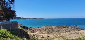 a view of the ocean from a rocky beach at Grand studio lumineux à côté des plages in Dinard