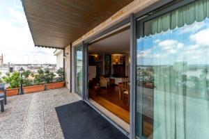 einen Balkon mit Glasschiebetüren und Stadtblick in der Unterkunft Attico tra i due Mari in Novoli
