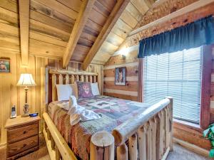 1 dormitorio con 1 cama en una cabaña de madera en Fox Den, 2 Bedrooms, Sleeps 4, Whirlpool Tub, Deck, Yard, Hot Tub, en Gatlinburg