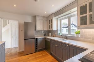 a kitchen with a stainless steel refrigerator and a window at 4 Bed City House with Private Garden and Parking in Winchester
