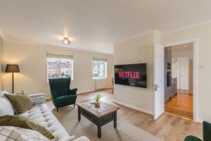 a living room with a couch and a tv at 4 Bed City House with Private Garden and Parking in Winchester
