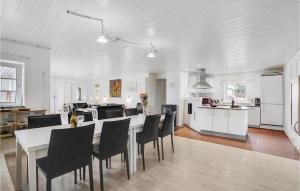 cocina y comedor con mesa y sillas en Amazing Home In Fan With Sauna, Wifi And Indoor Swimming Pool, en Sønderho
