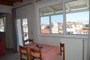 een tafel en stoelen in een kamer met een raam bij Anastasia Apartment in Zakynthos
