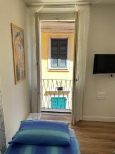 a bedroom with a bed and a balcony with a window at Holiday Studio in Centro Storico Intra in Intra