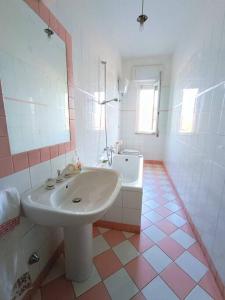 a white bathroom with a sink and a tub at Il giardino delle rose in Avezzano