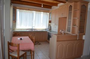 uma cozinha com uma mesa e uma pequena mesa e cadeiras em Anastasia Apartment em Zakynthos