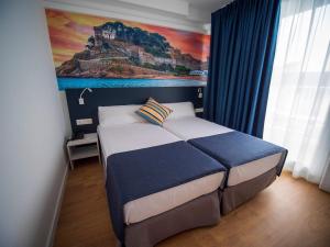 a bedroom with a bed with a painting on the wall at Hotel Don Juan Tossa in Tossa de Mar