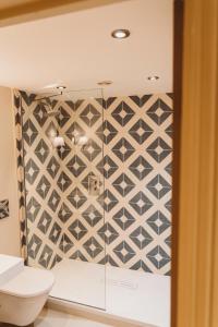 a bathroom with a geometric tile wall at Finch's Arms in Oakham