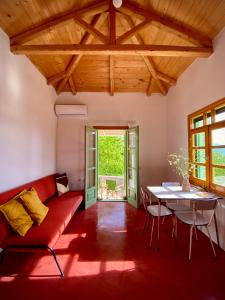 a living room with a red couch and a table at Lichada Villa's in Likhás