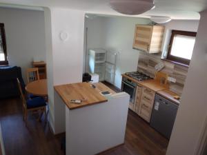 a small kitchen with a counter and a table at Hamvas Vendégház in Tiszakécske