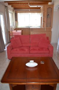 a red couch in a living room with a coffee table at Anastasia Apartment in Zakynthos Town