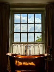 a bath tub sitting in front of a window at The Barnsdale in Oakham