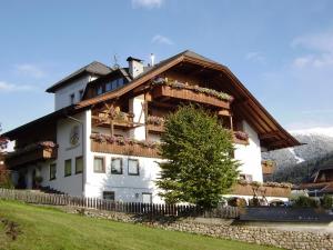 a large white building with a wooden roof at Pension Schifferegger in Maranza