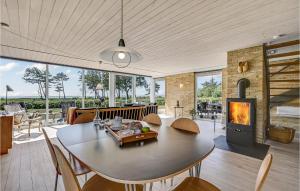 a living room with a table and chairs and a fireplace at Amazing Home In Knebel With Kitchen in Skødshoved Strand