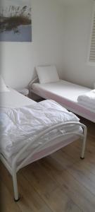 two beds in a room with white sheets at de blinker in Knokke-Heist