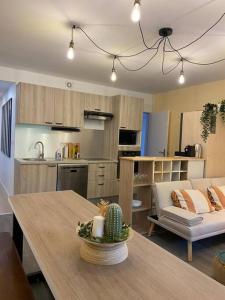 eine Küche und ein Wohnzimmer mit einem Tisch und einem Sofa in der Unterkunft Sleep In La Mulatière in La Mulatière