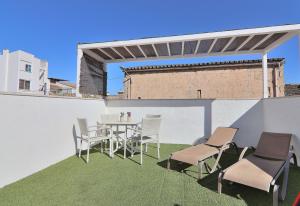 een patio met een tafel en stoelen op een dak bij Casa Jaume II 262 By Mallorca Charme in Muro
