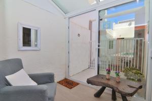 ein Wohnzimmer mit einem Sofa, einem Tisch und einem Fenster in der Unterkunft Casa Jaume II 262 By Mallorca Charme in Muro