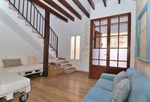 ein Wohnzimmer mit einem blauen Sofa und einer Treppe in der Unterkunft Casa Jaume II 262 By Mallorca Charme in Muro
