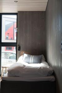 ヘニングスヴァールにあるSeafront appartment Henningsværの窓付きの部屋の角にあるベッド