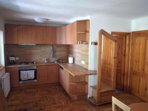 a kitchen with wooden cabinets and a counter top at Halász Vendégház Tiszakécske in Tiszakécske