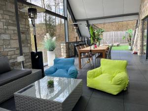 a patio with a couch and chairs and a table at Loft de prestige au pied du circuit in Francorchamps