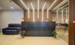 a lobby with a blue couch and a table at Treebo De Alphabet Kondapur in Hyderabad