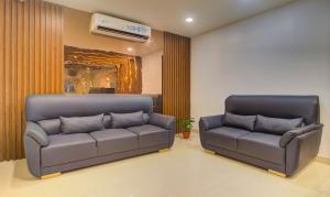 a living room with two couches and a couch at Treebo Trend De Alphabet Kondapur in Hyderabad