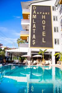 a hotel with a swimming pool in front of a building at Alanya Damlataş Apart in Alanya