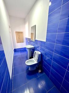 uma casa de banho em azulejos azuis com um WC e um lavatório em Hotel 7 em Kapchagay