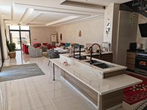 a kitchen with a sink and a living room at The Legend Villa فيلا الاسطوره in Sowayma
