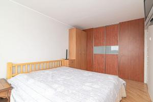 1 dormitorio con 1 cama grande y armarios de madera en Vilnius view apartments (95 sqm), en Vilna