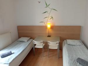 a room with two beds and a table and chairs at Central Station Hostel in Warsaw