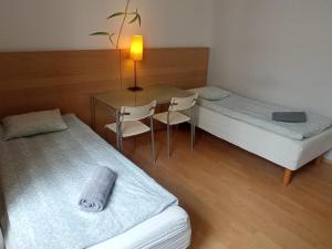 a room with two beds and a table and chairs at Central Station Hostel in Warsaw