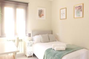 een witte slaapkamer met een bed en een raam bij Habitación centro Oviedo cerca de estación de buses y trenes in Oviedo