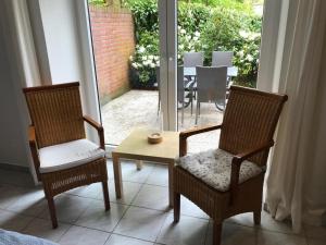 2 Stühle und ein Tisch in einem Zimmer mit Fenster in der Unterkunft Ferienwohnung am Mühlenpark in Timmendorfer Strand