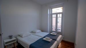 1 dormitorio con 2 camas y ventana en The Graça Apartment, en Lisboa