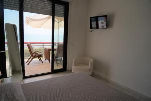 um quarto com uma cama e uma varanda com um guarda-sol em SunRise Apartments em Termoli