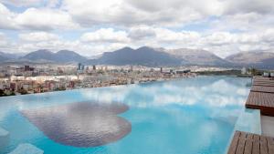 a large pool of water with a city in the background at Arka Art Hotel in Tirana