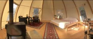 a bedroom with a bed and a fireplace in a tent at Frisbo Lodge - Romantic night in a dome tent lake view in Bjuråker
